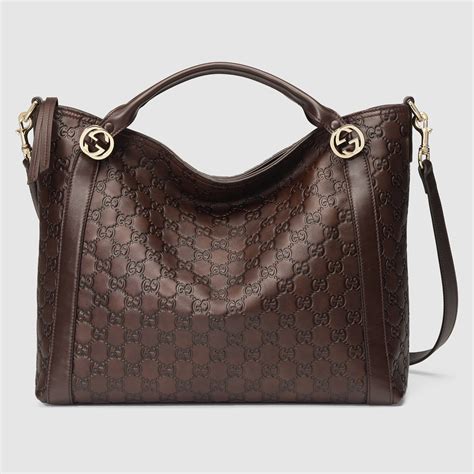 brown gucci handbag next to a black handbag